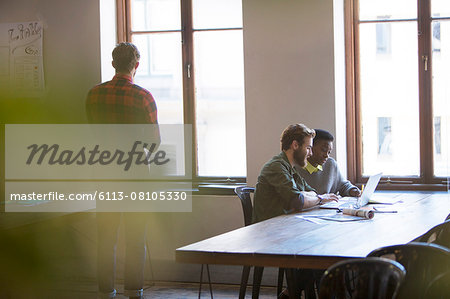 Creative business people working at laptop in office