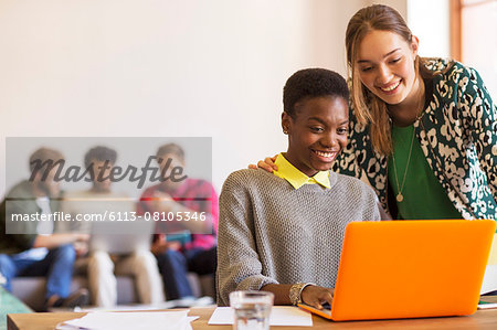 Smiling creative businesswomen working at laptop in office Smiling creative businesswomen working at laptop in office