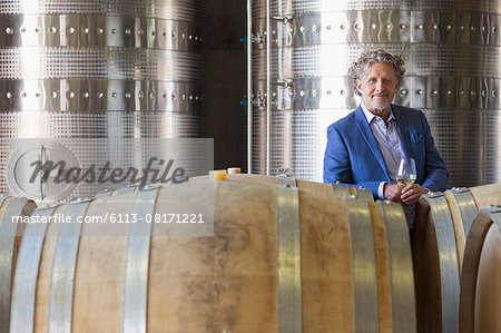 Portrait confident vintner in winery cellar