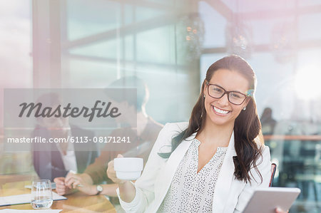 Portrait confident businesswoman with digital tablet and coffee in office