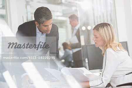 Business people reviewing paperwork in conference room