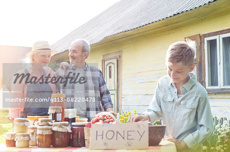 Grandparents and grandson selling honey