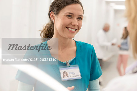 Smiling nurse talking to doctor in hospital corridor