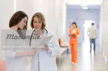 Doctor and patient reviewing medical record in hospital corridor