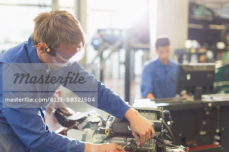 Mechanic working on engine in auto repair shop