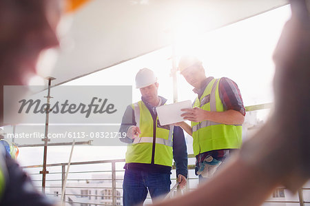 Construction workers with digital tablet at construction site