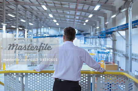 Supervisor on platform looking out over factory Supervisor on platform looking out over factory