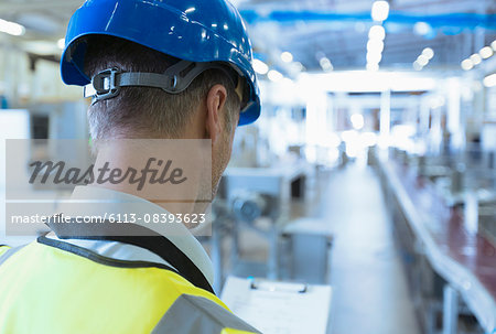 Worker with clipboard in factory