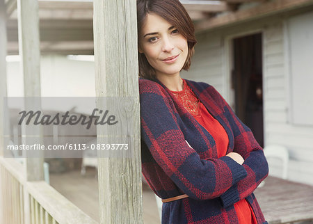 Portrait smiling brunette woman in sweater on porch