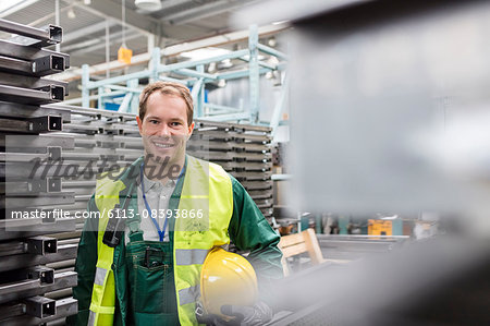 Portrait smiling worker in protective workwear in steel factory