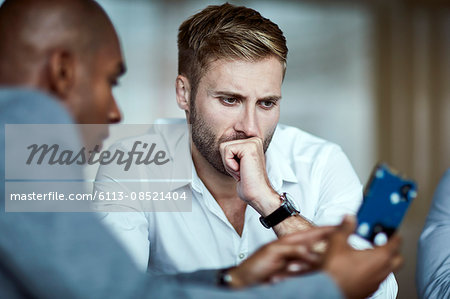 Serious businessmen examining part