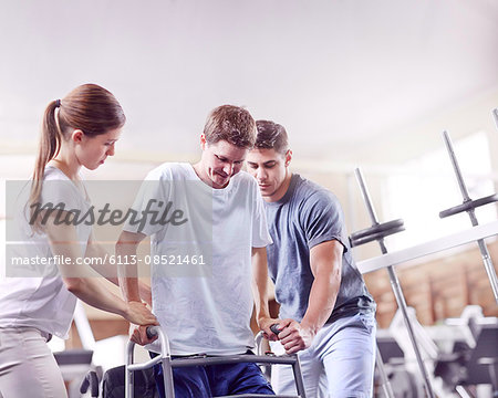 Physical therapists helping man with walker