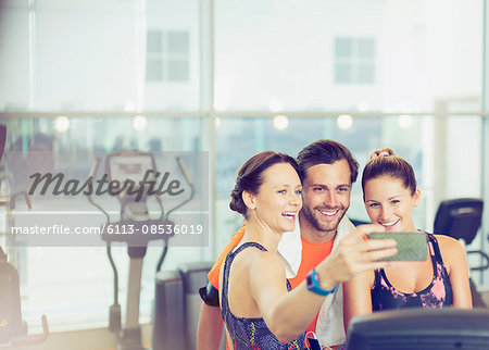 Smiling friends taking selfie at gym