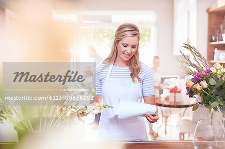 Florist reviewing paperwork in flower shop