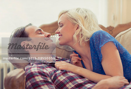 Affectionate couple laying on sofa