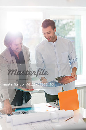 Creative businessmen reviewing photography proofs in office