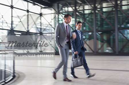 Corporate businessmen walking in modern lobby