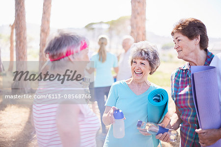 Senior women talking after yoga class in sunny park