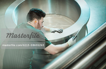 Worker inspecting part in steel factory