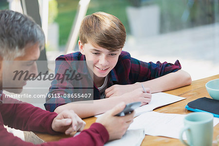 Father with calculator helping son with math homework