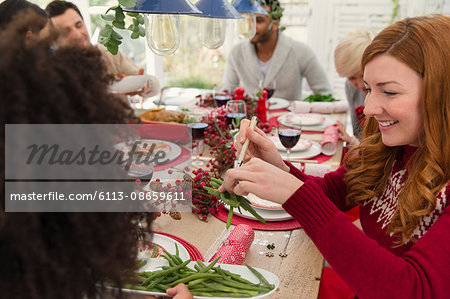 Woman serving green beans at Christmas dinner