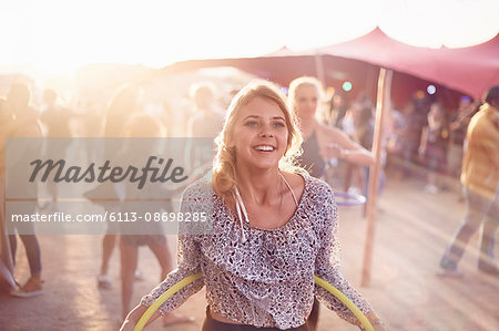 Smiling young woman with plastic hoop at music festival