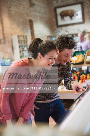 Couple shopping at display case in market