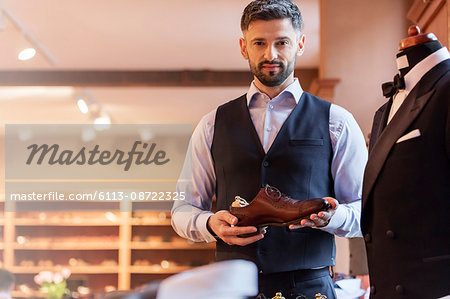 Portrait confident businessman holding dress shoe in menswear shop Portrait confident businessman holding dress shoe in menswear shop