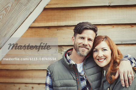 Portrait smiling couple hugging outside cabin