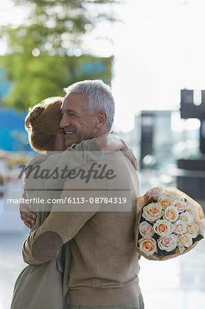 Couple with rose bouquet hugging