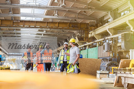 Steel workers walking and talking in factory