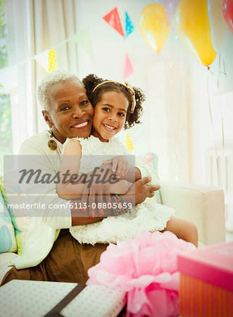 Portrait smiling grandmother and granddaughter hugging at birthday party