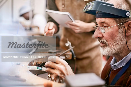 Focused jeweler working in workshop