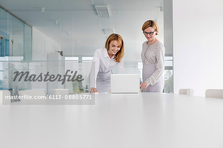 Businesswomen working at laptop in conference room