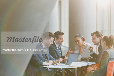 Business people using laptop in meeting