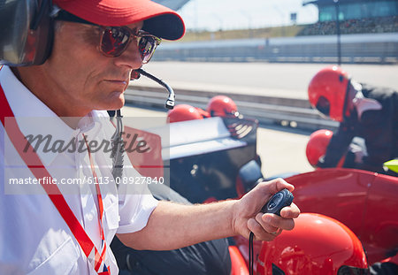 Manager with stopwatch timing formula one pit stop practice session