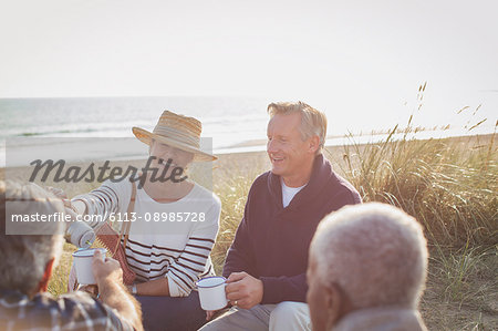 Senior couples drinking coffee on sunny beach