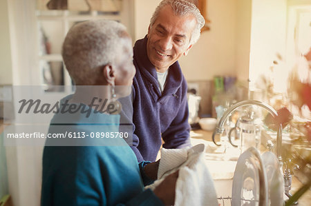 https://image1.masterfile.com/getImage/6113-08985780em-senior-couple-talking-and-doing-dishes-in-kitchen-stock-photo.jpg