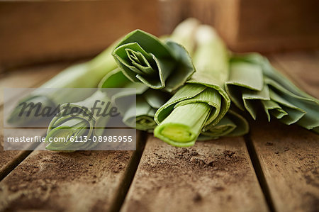 Still life close up fresh, organic, healthy green leek stems on wood