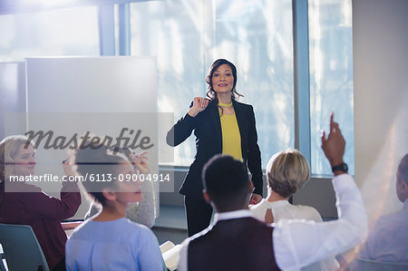 Businesswoman leading meeting, answering audience questions