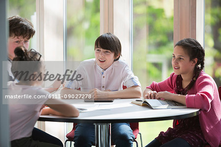 Students talking at table in library