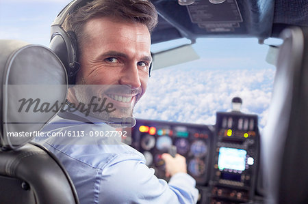 Portrait smiling, confident male pilot flying airplane in cockpit