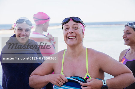 Portrait smiling, confident female open water swimmers drying off with towels