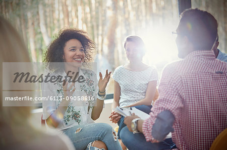 Smiling woman talking and gesturing in group therapy session Smiling woman talking and gesturing in group therapy session