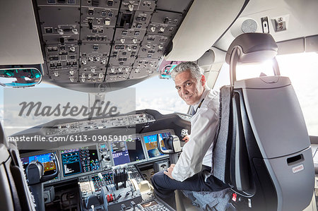 Portrait confident male pilot in airplane cockpit