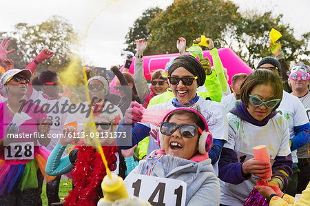 Portrait playful runners with holi powder at charity run in park