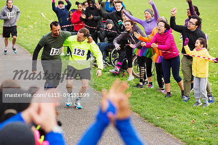 Man helping injured runner finish charity run in park