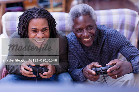 Happy grandfather and grandson playing video game