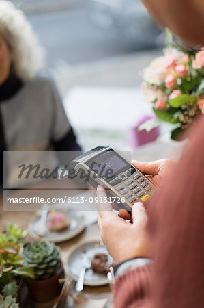 Cashier with credit card reader in cafe