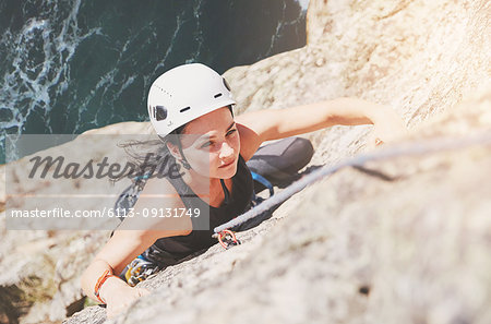 Focused, determined female rock climber scaling rock